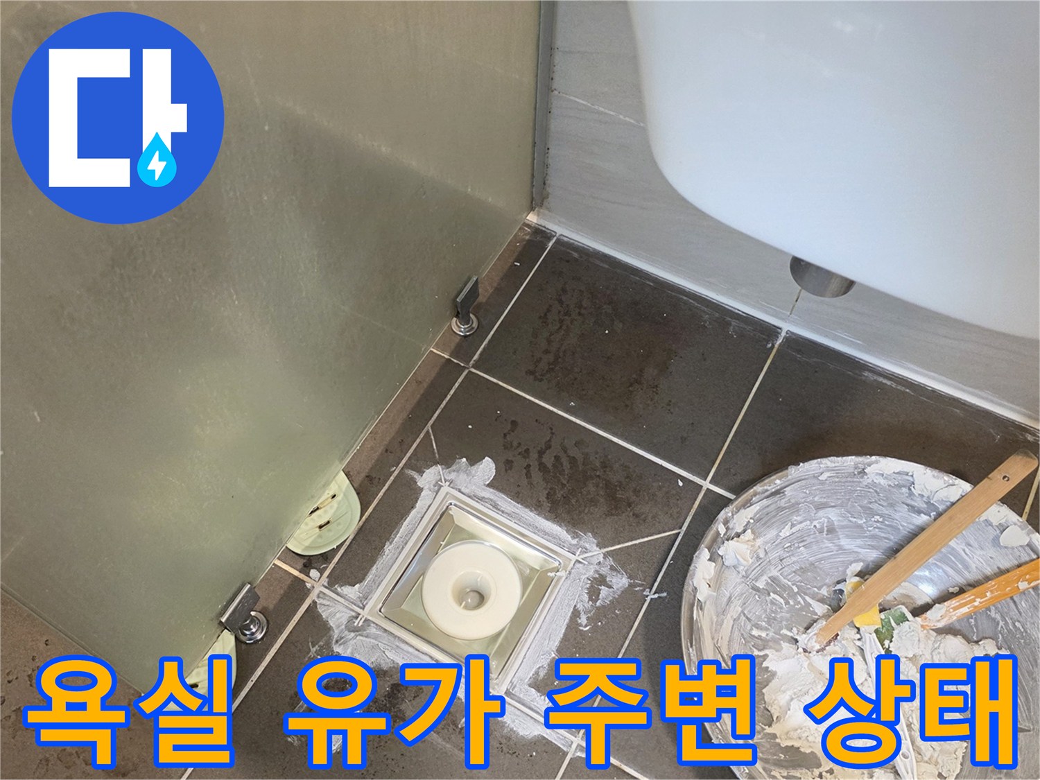 유가 탈거 후 노출된 배수구 주변의 젖은 타일 표면