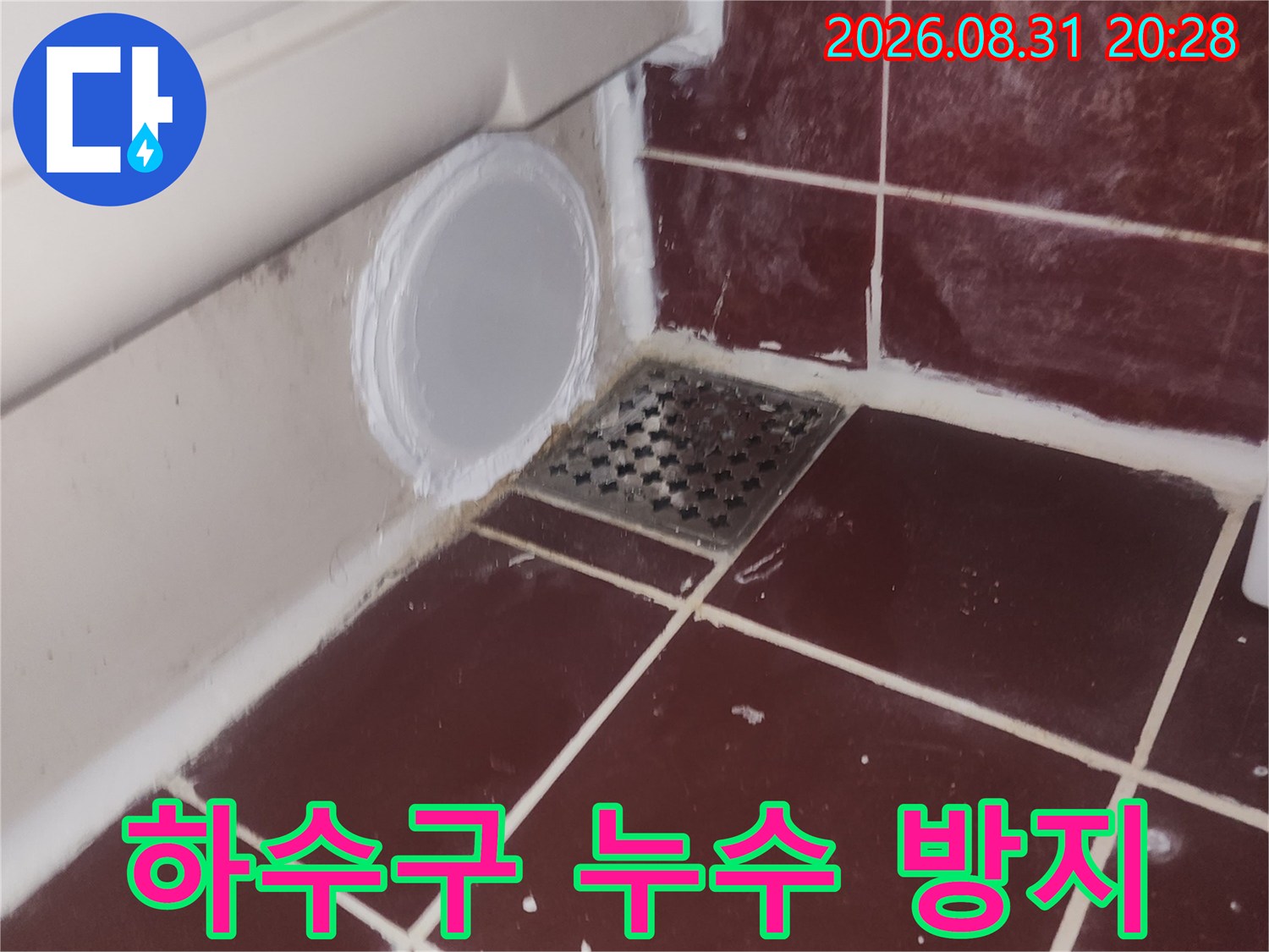붉은색 욕실 타일 바닥의 하수구 유가와 배관 연결 부위 사진