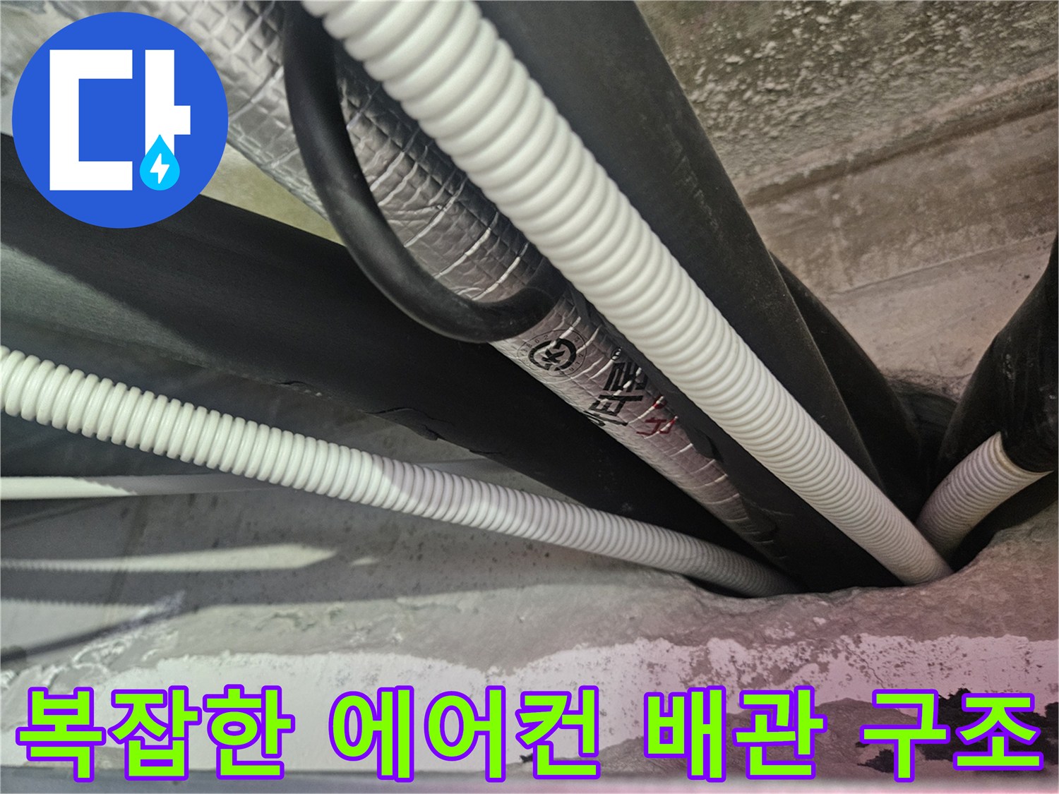 천장 내부의 얽혀 있는 에어컨 드레인 호스와 보온재 배관 상태를 보여주는 사진입니다.