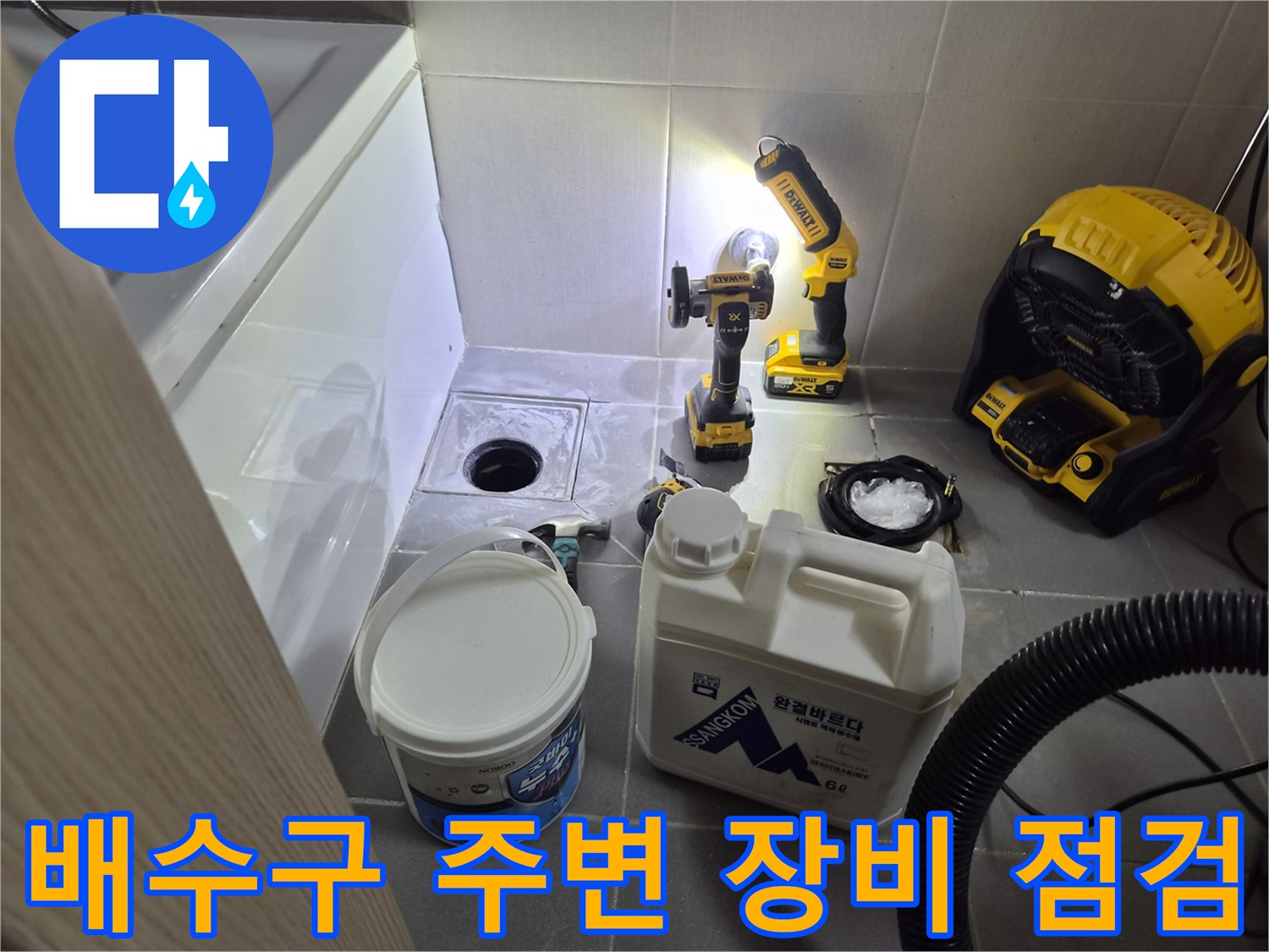 화장실 배수구 주변에 설치된 드릴과 청소 장비들