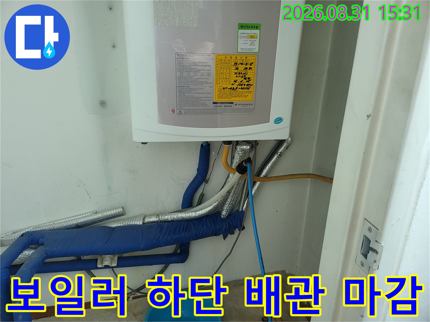 보일러 아래쪽으로 연결된 파란색과 은색의 다양한 배관들