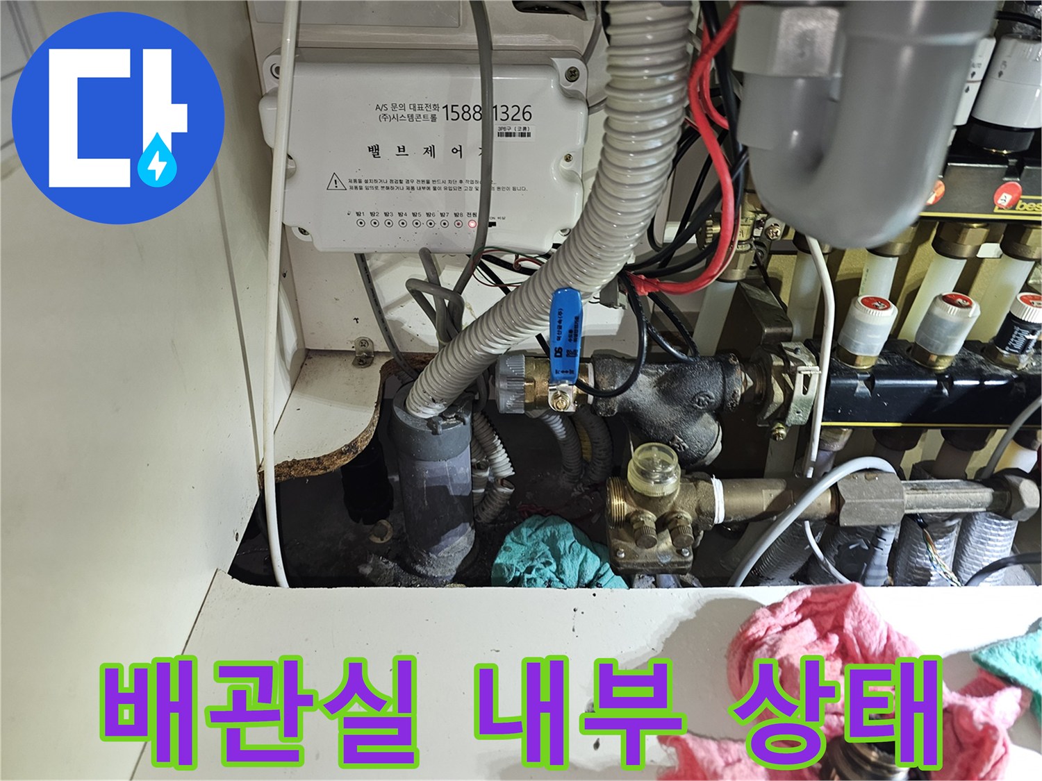 복잡하게 연결된 난방 배관과 제어 박스가 있는 현장 사진입니다.