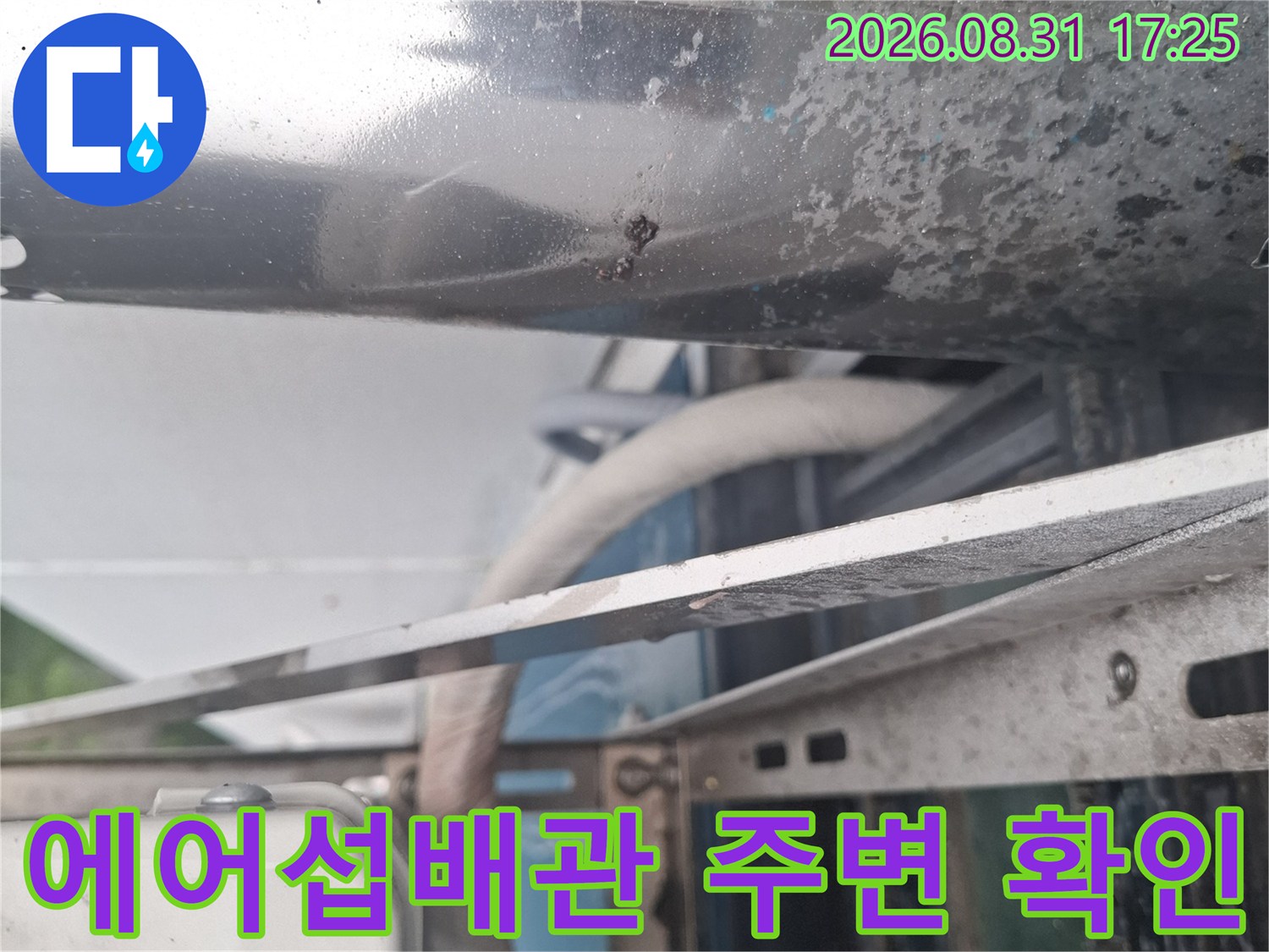 은색 금속 부품과 에어컨 배관이 연결된 지점을 보여주는 사진입니다.