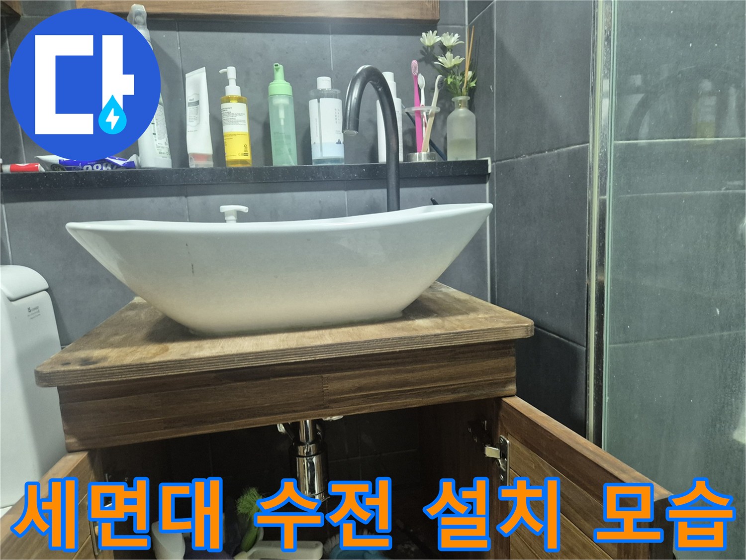 하얀색 세면대와 검은색 수전이 설치된 욕실 모습