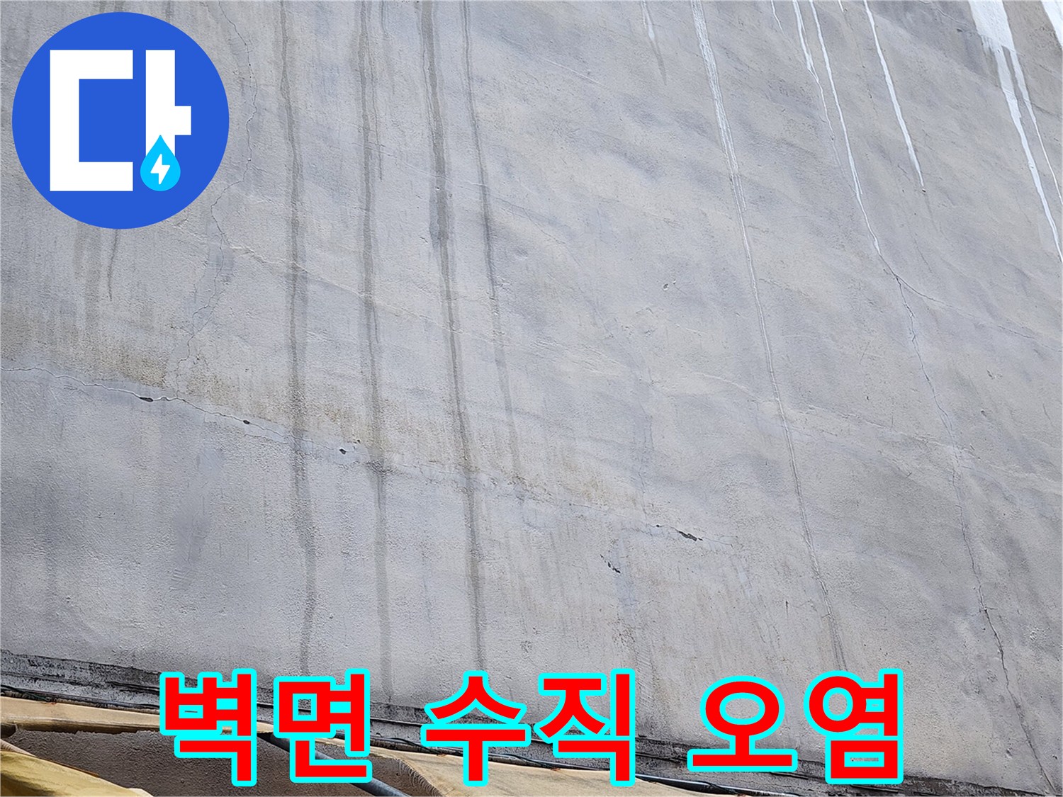 회색 콘크리트 벽면-수직으로 길게 이어진 검은 얼룩