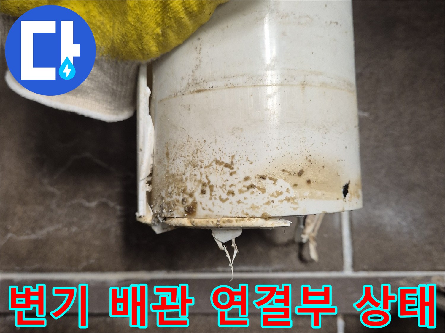 오염된 변기 오수관 입구와 주변 타일의 상태를 근접 촬영한 사진