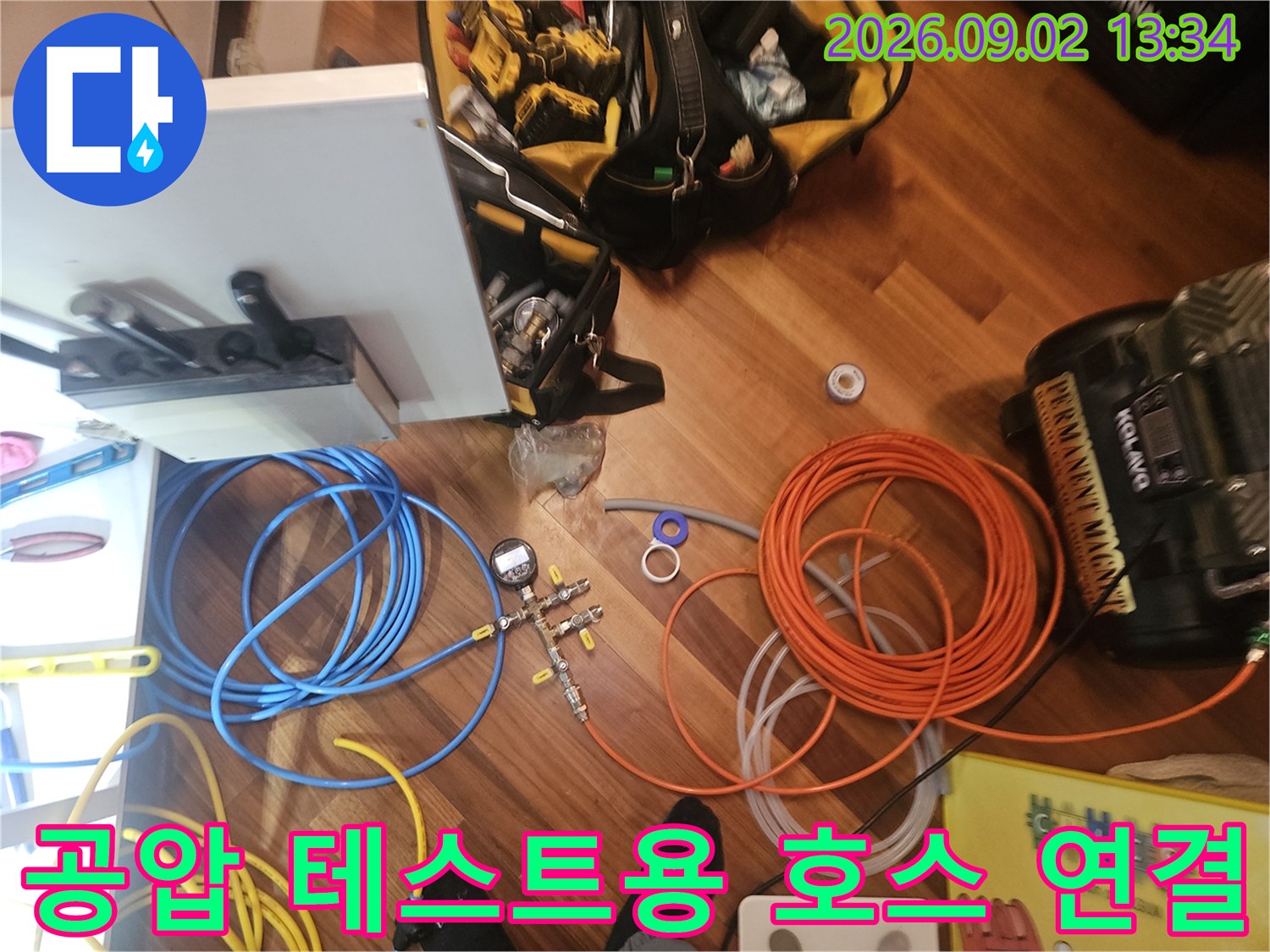 배관 점검을 위해 분배기에 연결된 파란색과 주황색 압력 호스