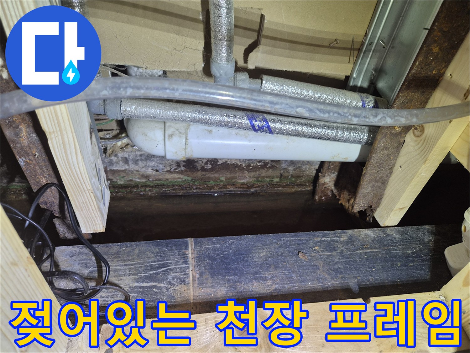 습기에 노출되어 어둡게 변한 천장 내부 목재와 배관