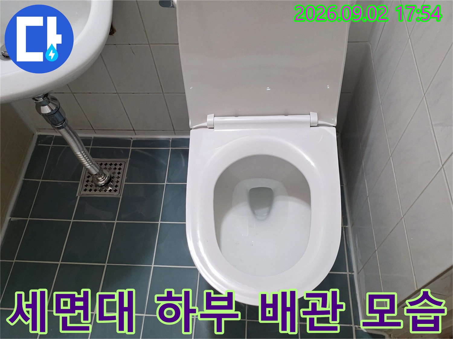 세면대 아래 금속 배관과 변기 하단 타일 부위 상세 사진