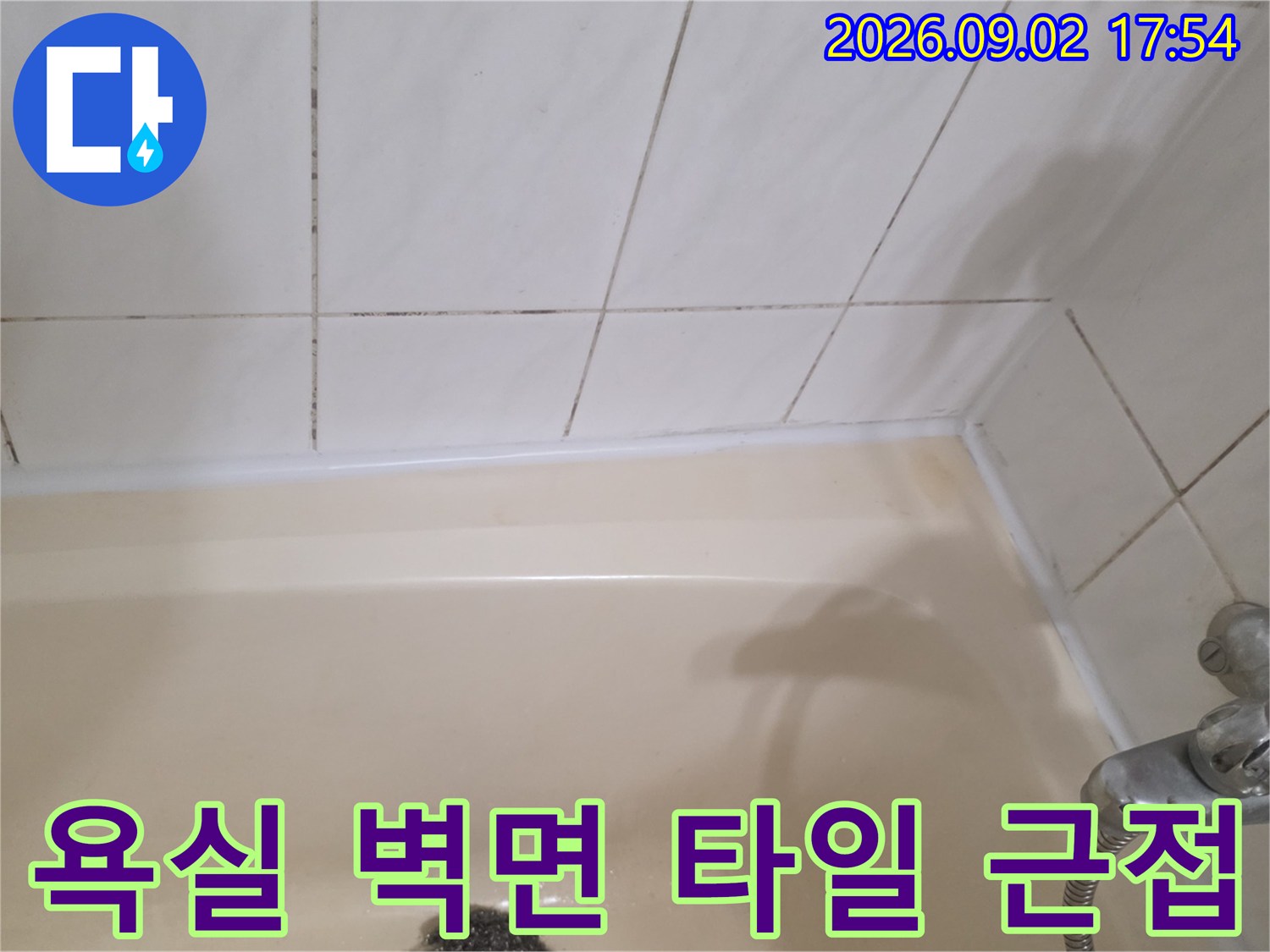 하얀색 욕실 타일과 수전 부위를 가까이서 촬영한 사진입니다.