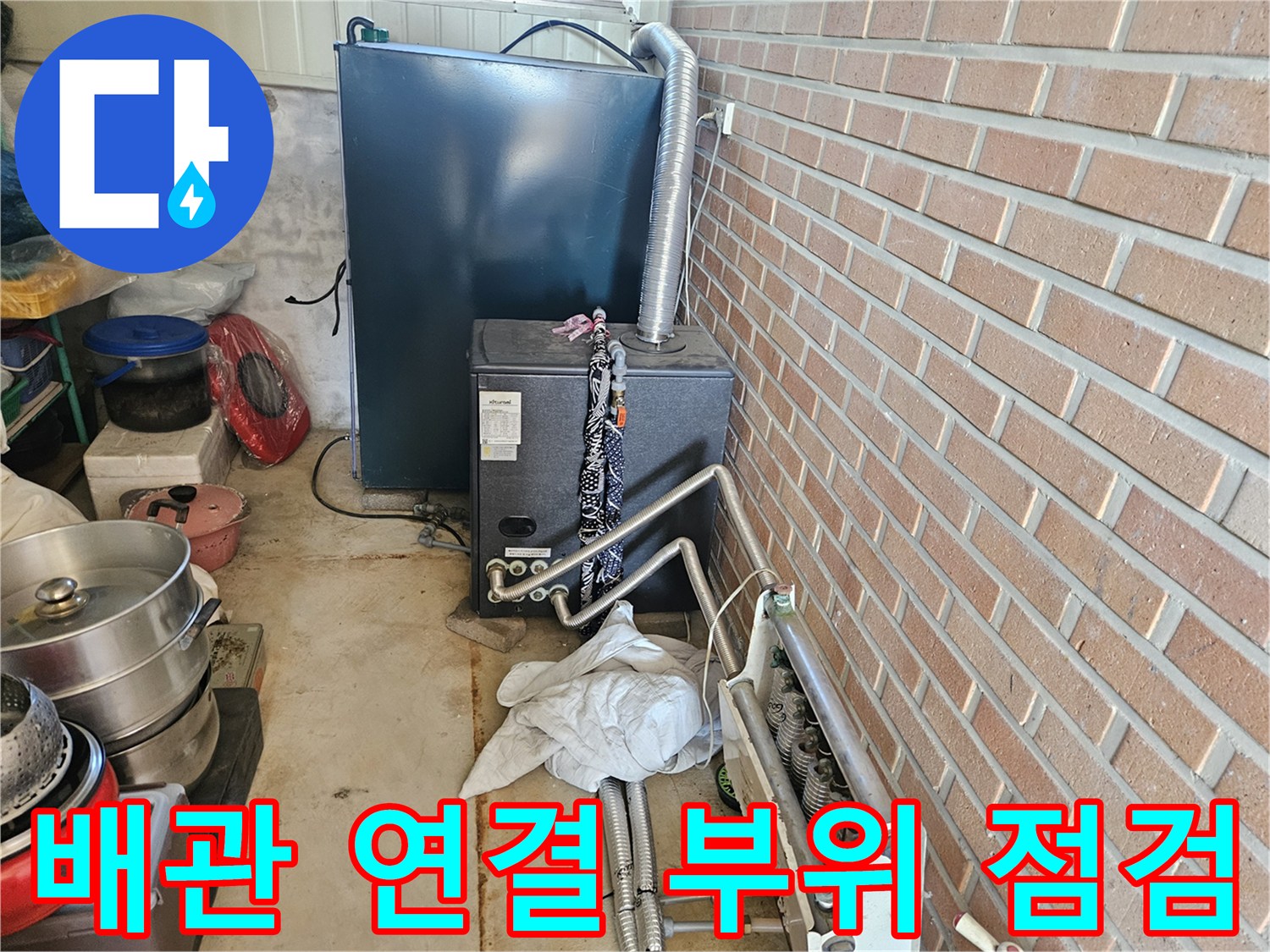 벽돌 벽면 옆에 설치된 금속제 배관과 밸브 장치