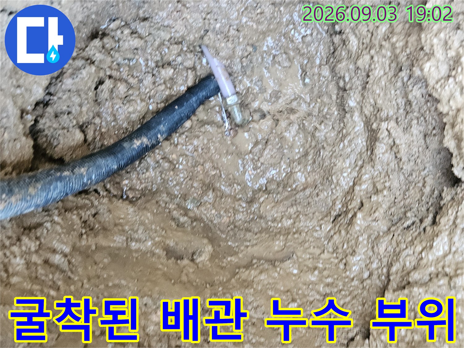 흙 속에 드러난-파손된 수도 배관의 연결부 모습입니다.