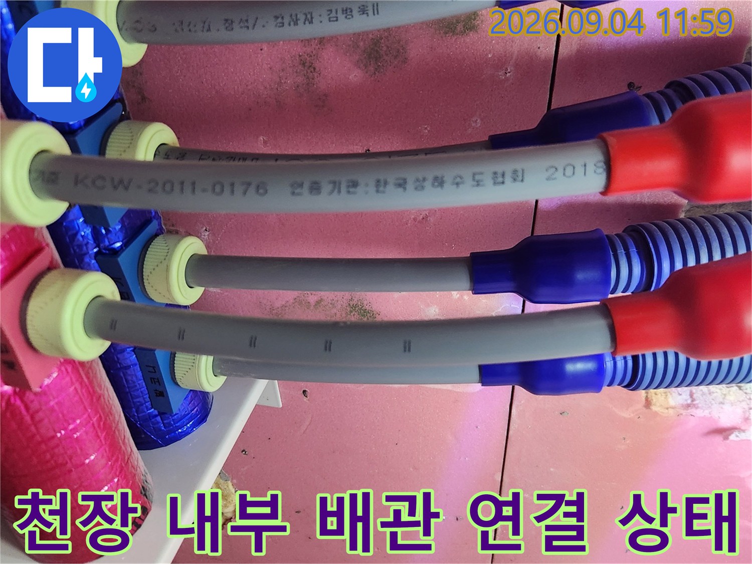 분홍색 보온재와 파란색 덮개가 있는 천장 배관의 상세 촬영본