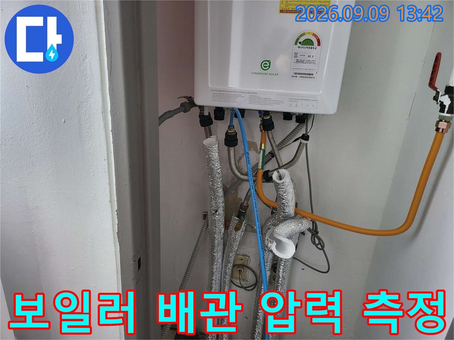 보일러 하단부에 연결된-파란색 호스와 배관들의-상세한 모습입니다.