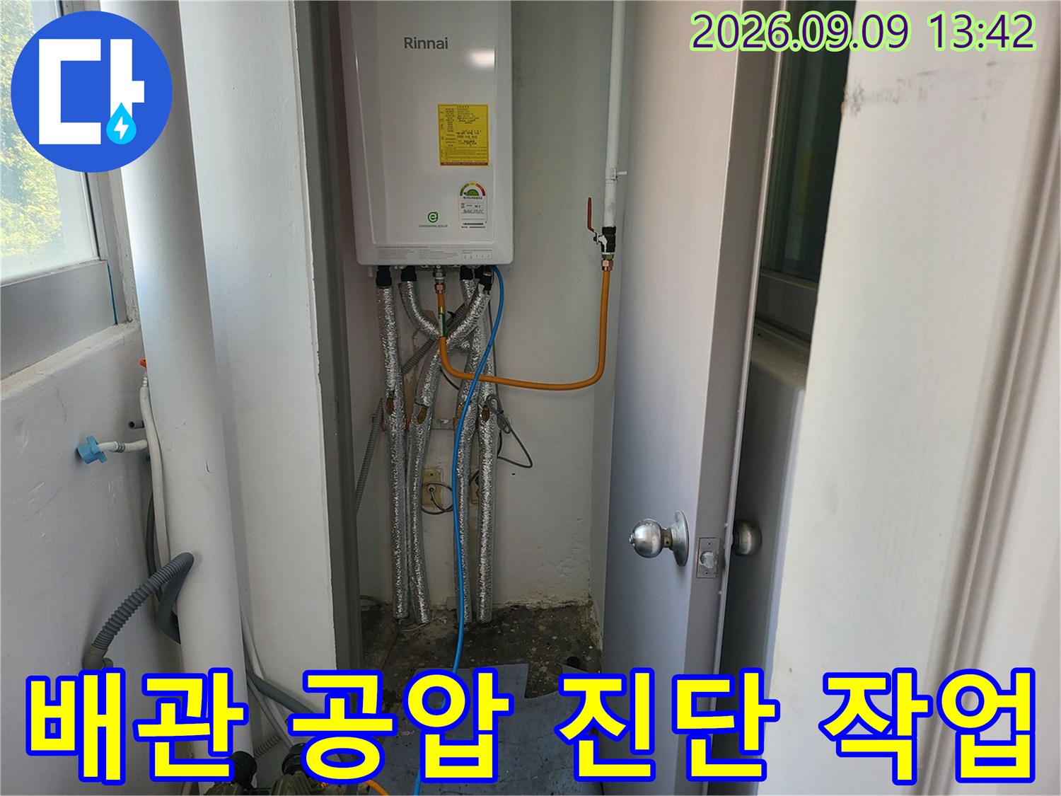 보일러 하부 배관에 연결된 테스트용 호스와 장비의 모습입니다.