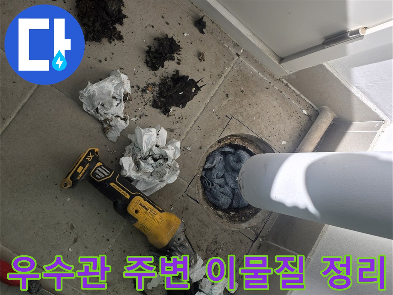 배관 하부의 오염된 잔해들과 작업용 전동 공구가 놓인 모습