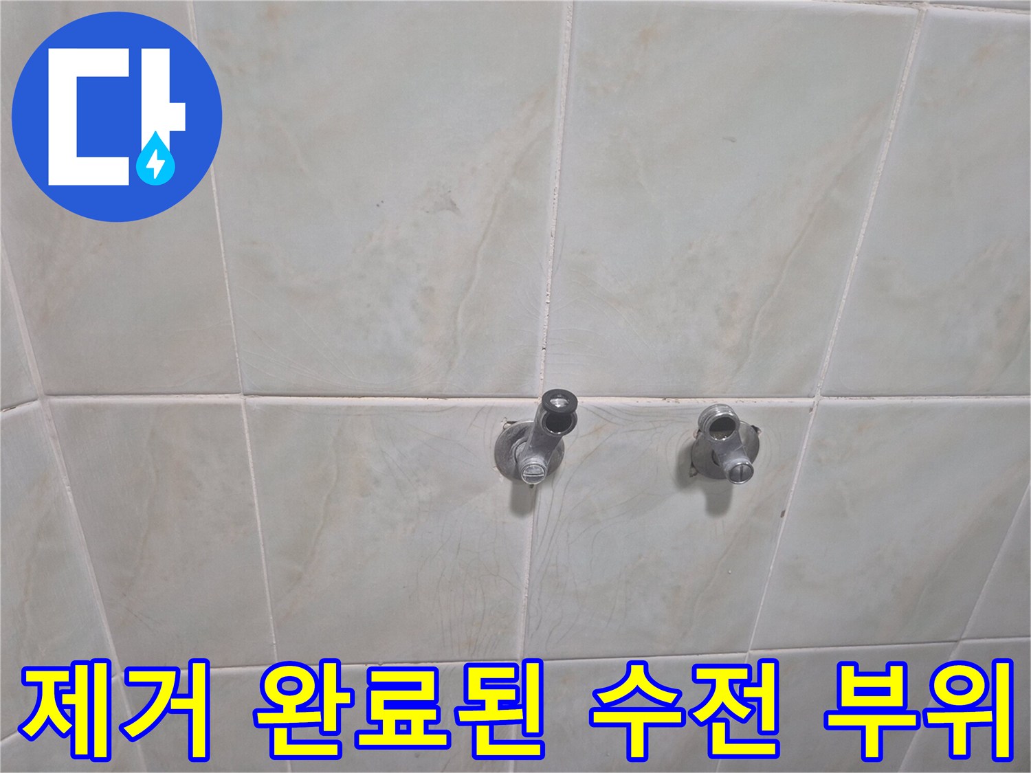 기존 샤워 수전이 제거되어 드러난 타일 벽면 배관