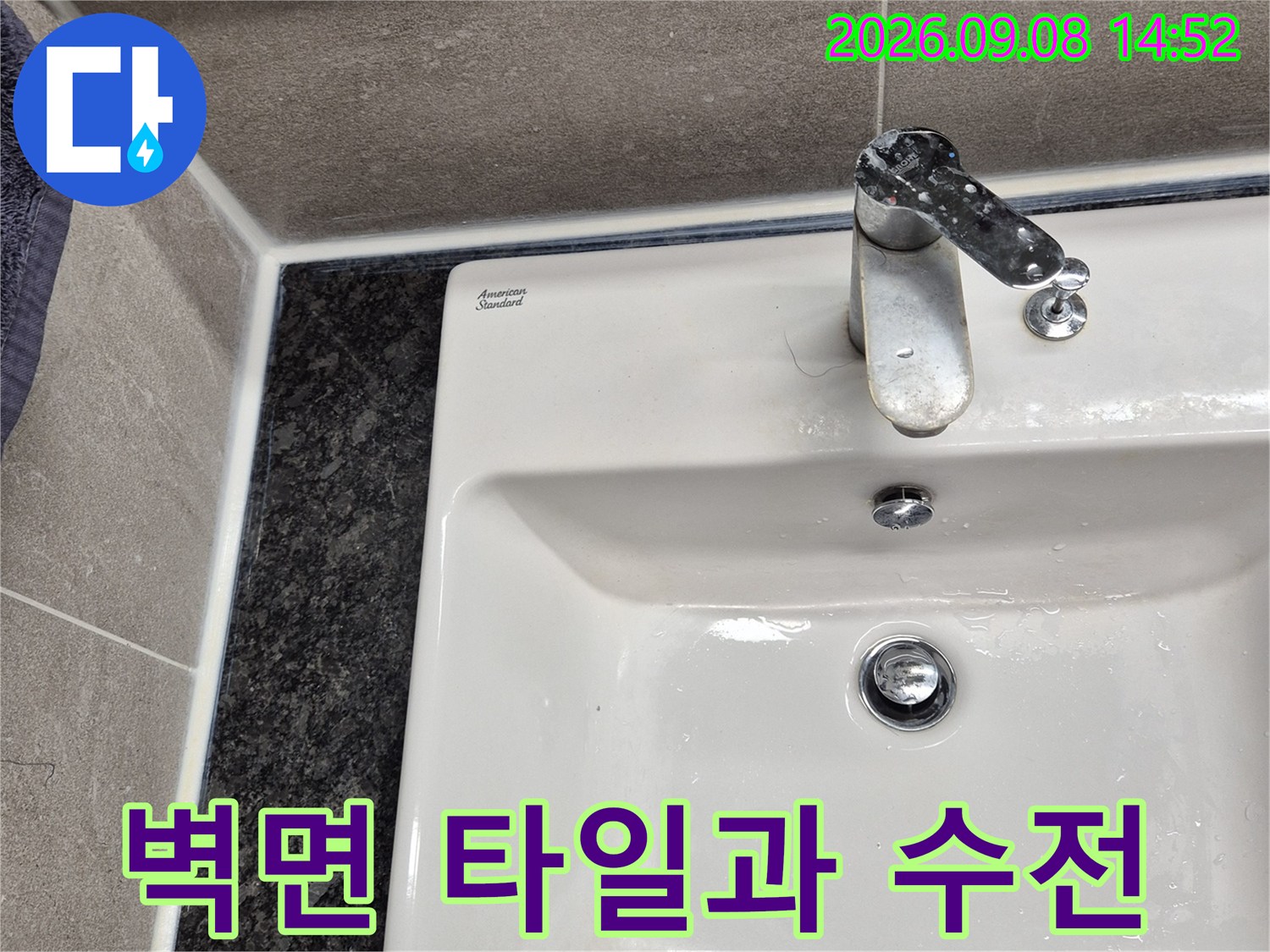 벽면 타일과 수도꼭지가 설치된 욕실 내부의 모습입니다.