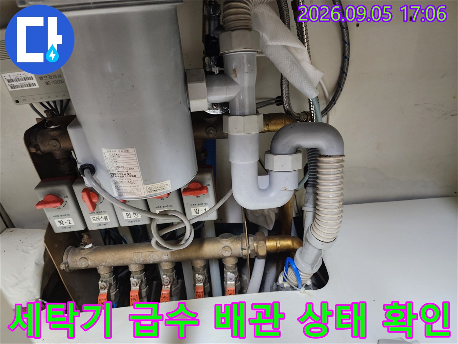 싱크대 하부에 위치한 세탁기용 급수 밸브와 배관 연결부입니다.