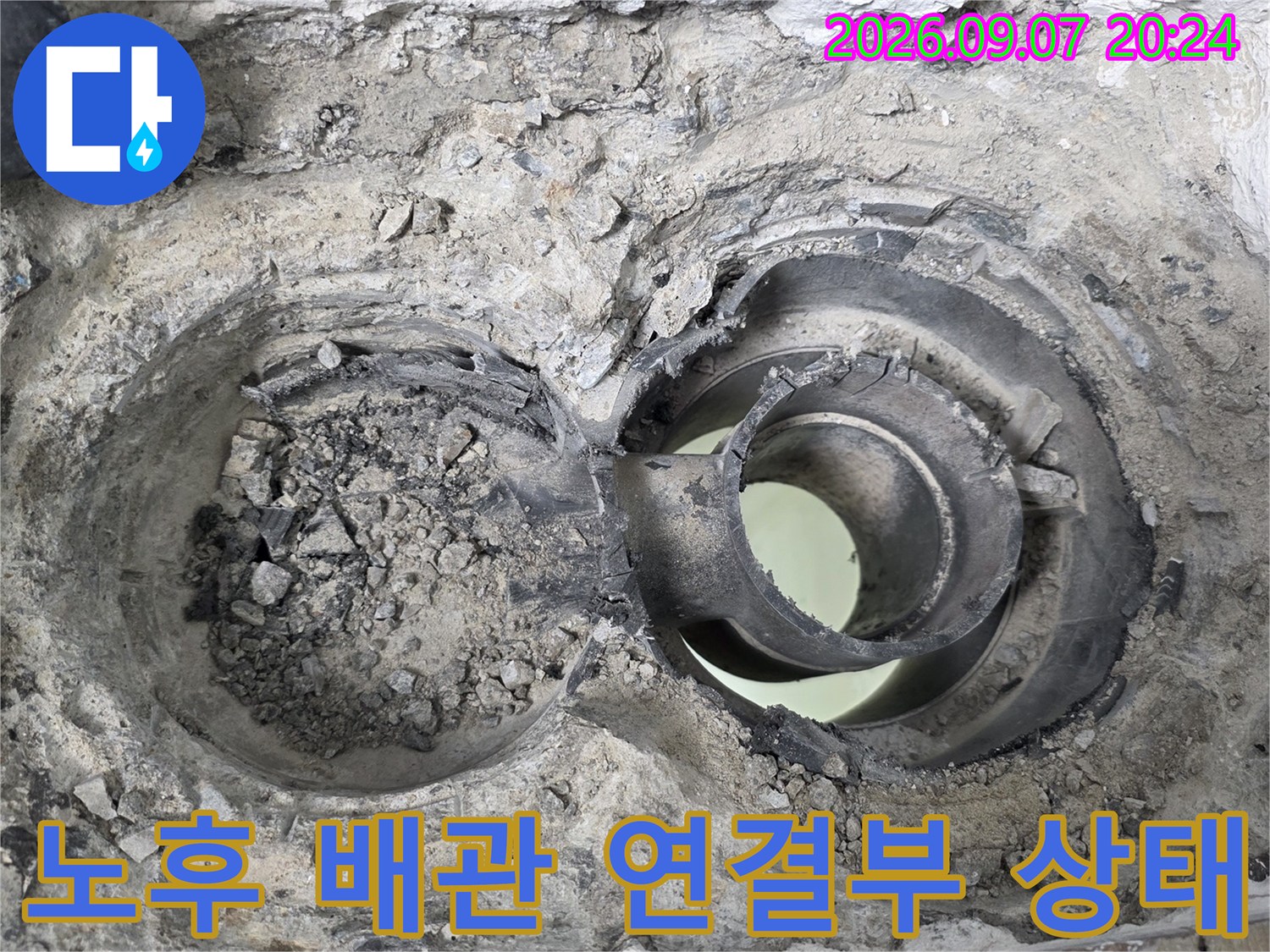 배수관 연결 부위의 틈새와 노후된 마감재를 상세히 나타내는 사진입니다.