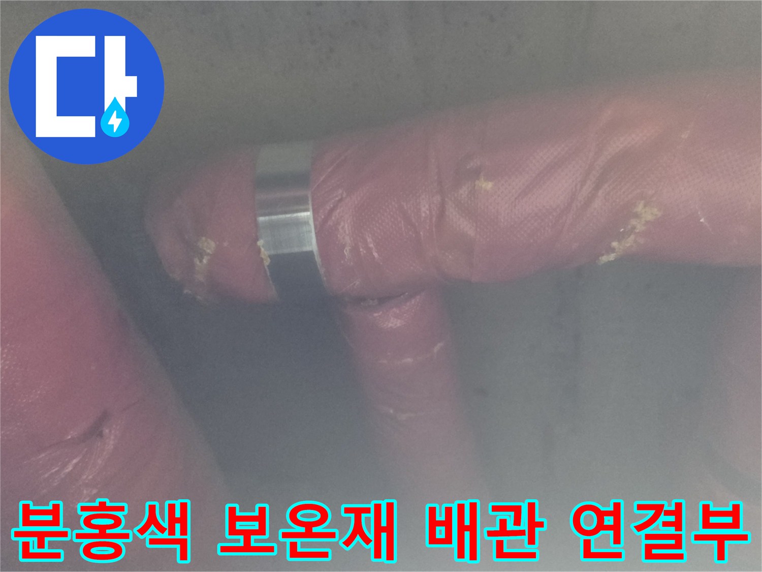 의정부 현장의 분홍색 보온재로 감싸진 배관과 금속 고정 밴드 근접 촬영