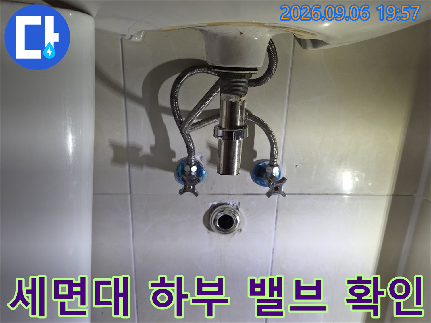 세면대 아래 설치된 앵글 밸브와 급수 배관 모습