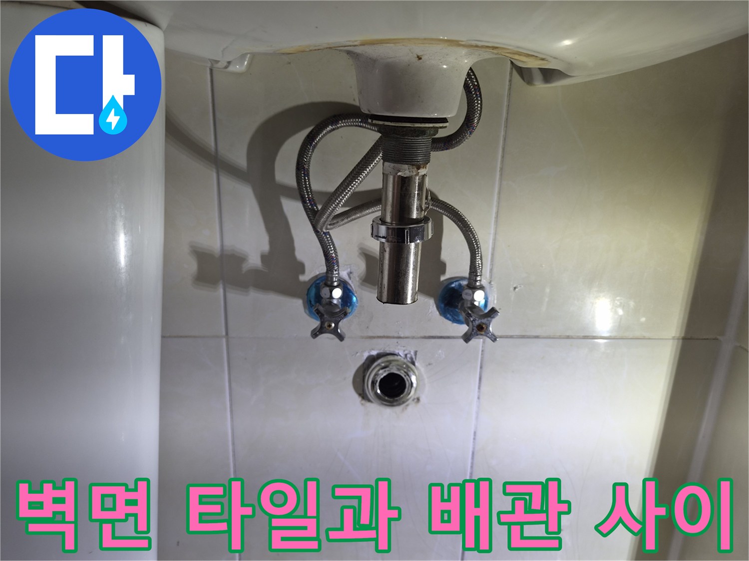세면대 하단 벽돌 타일 사이의 배관 노출 부위 촬영