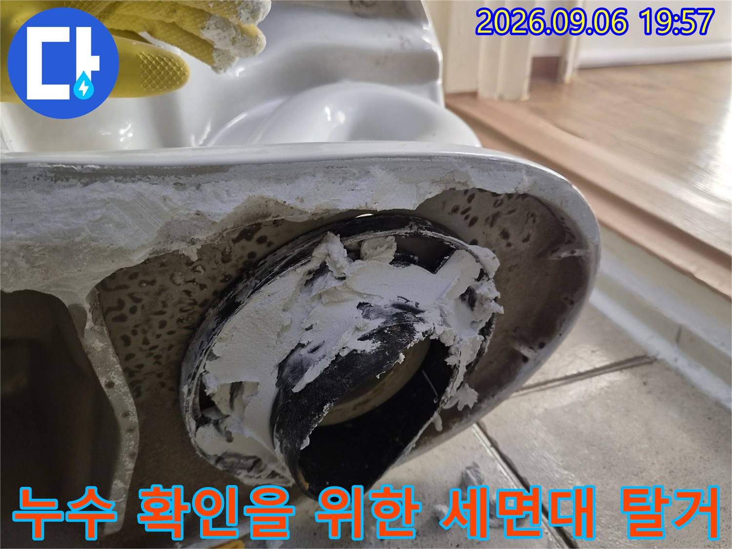 세면대를 제거한 후 드러난 배수 부속과 주변 타일의 누수 흔적 사진입니다.