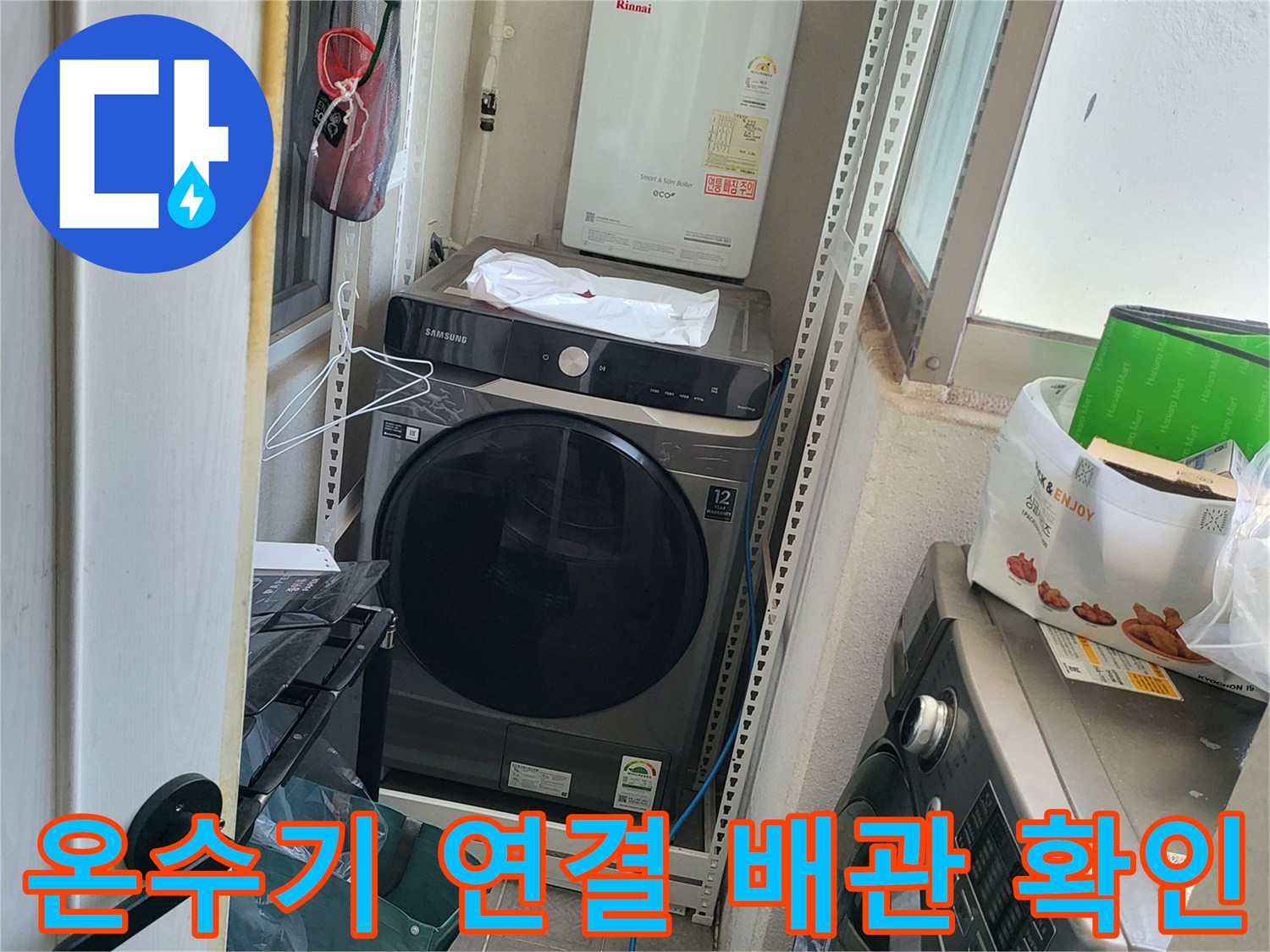 벽면에 설치된 온수기와 세탁기 뒤쪽의 수도 배관을 촬영한 사진입니다.