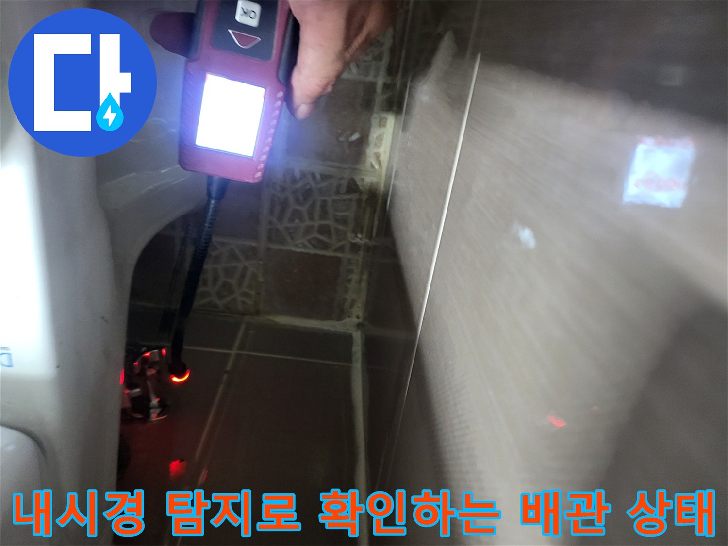 변기 뒤쪽 타일 틈새를 통해 매립된 급수관의 누수 여부를 점검하는 모습입니다.