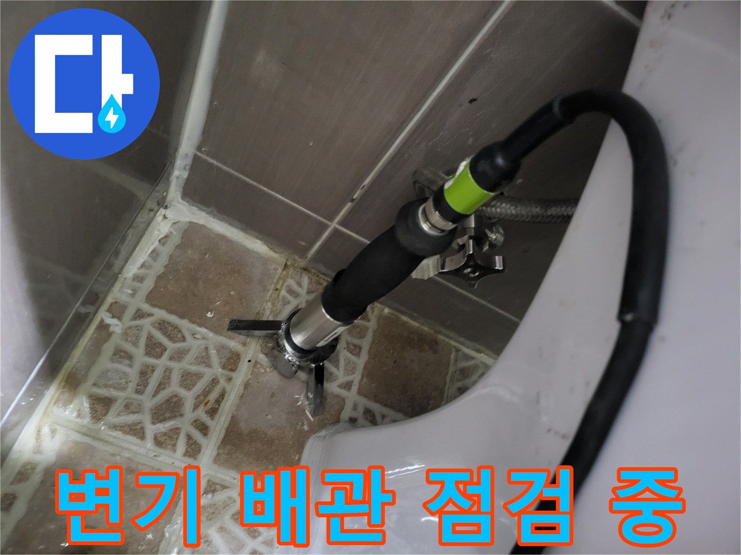 화장실 변기 급수 배관의 연결 부위를 정밀하게 점검하는 모습입니다.
