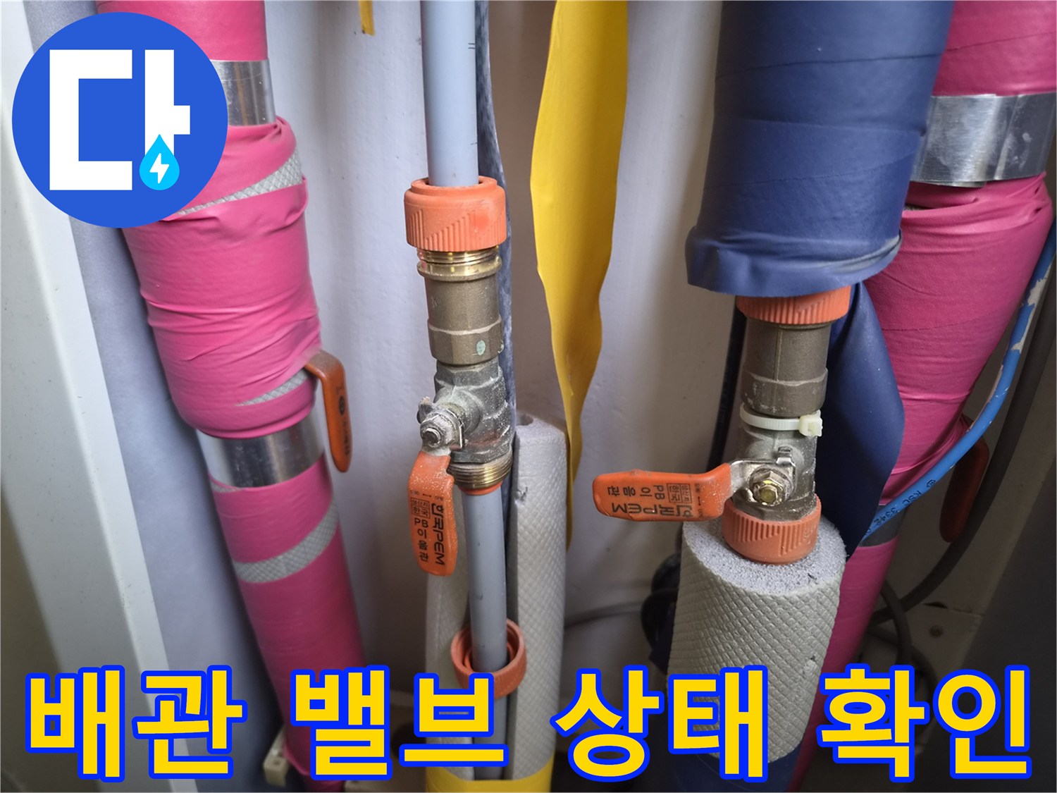 분홍색과 파란색 보온재로 감싸진 배관 연결 부위와 밸브 모습