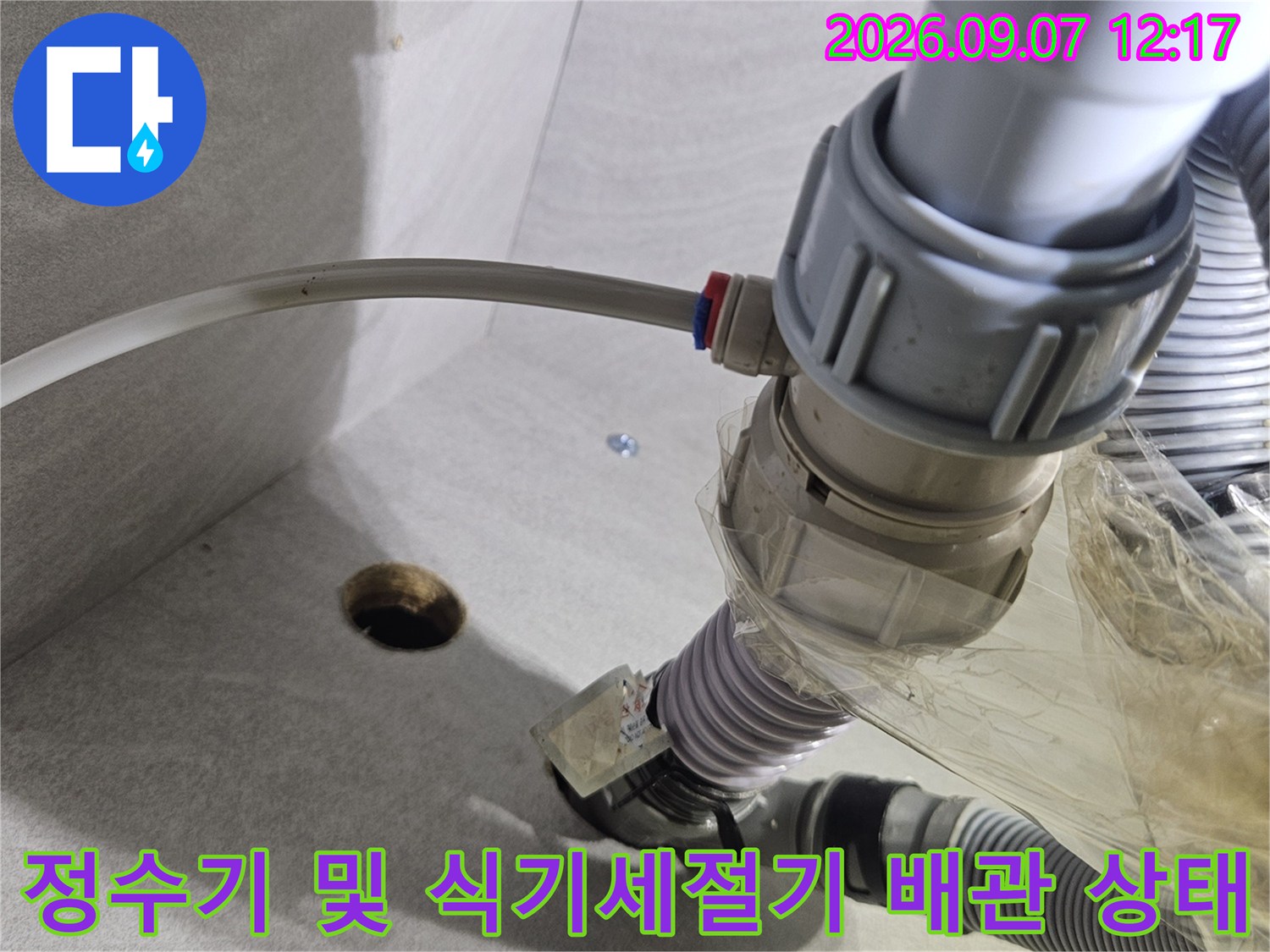 싱크대 아래 훼손된 정수기 호스와 연결 부위 근접 촬영