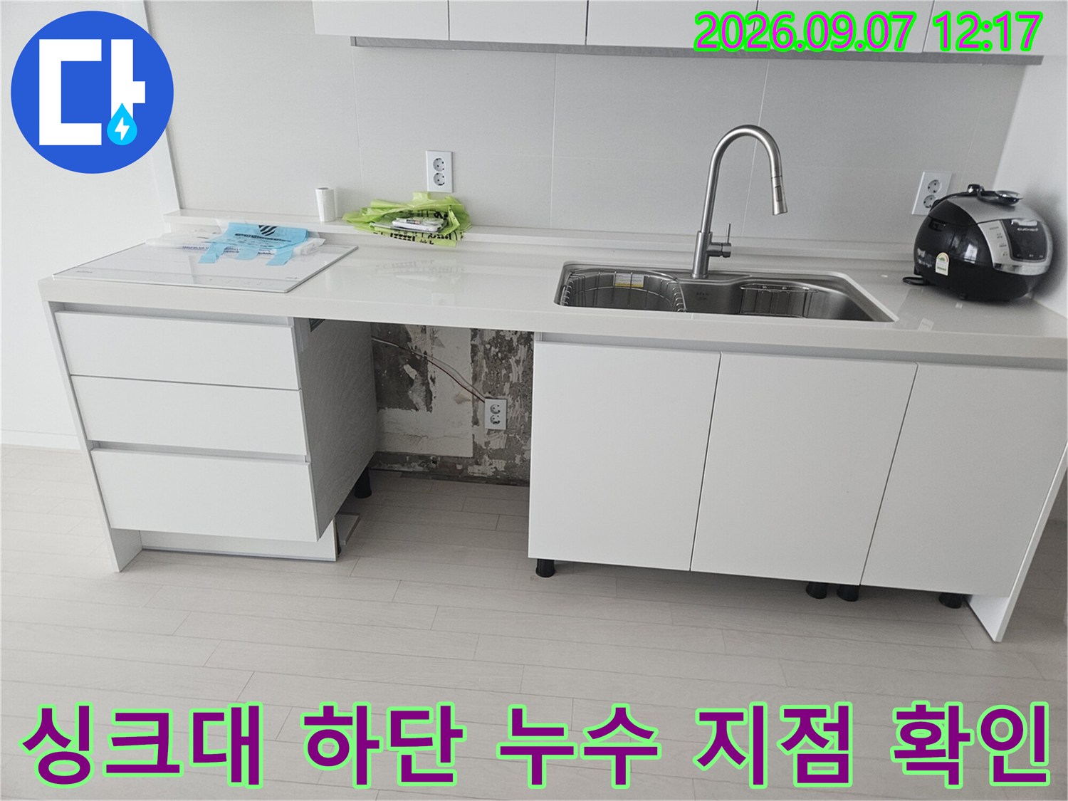 싱크대 하부장 내부의 훼손된 호스 연결 부위 상세 사진입니다.