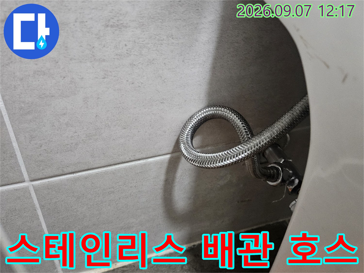 싱크대 하부장 아래에 배치된 굴곡진 스테인리스 호스 부위