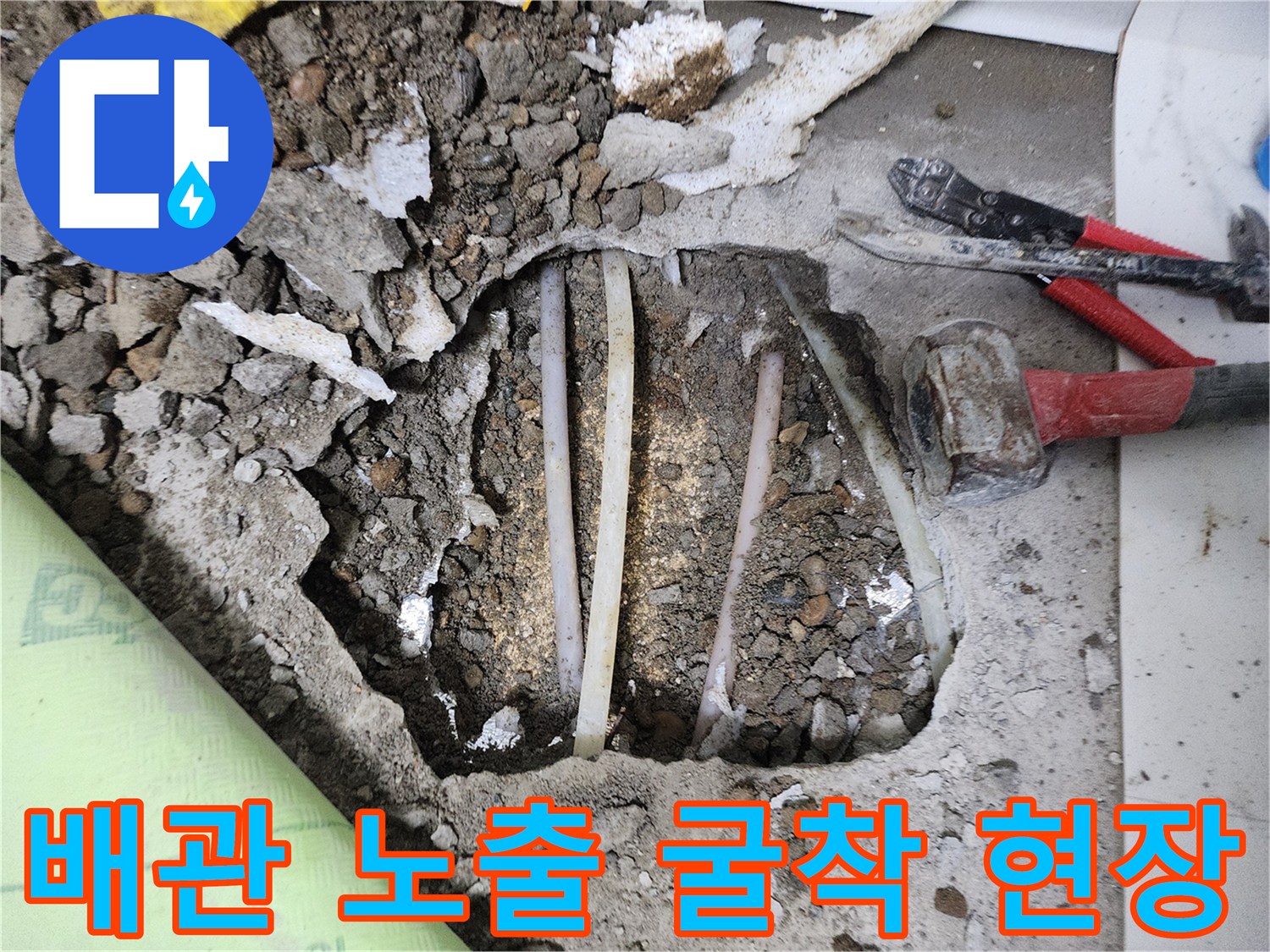 바닥을 깨어내고 드러난 수도 배관과 작업용 도구들