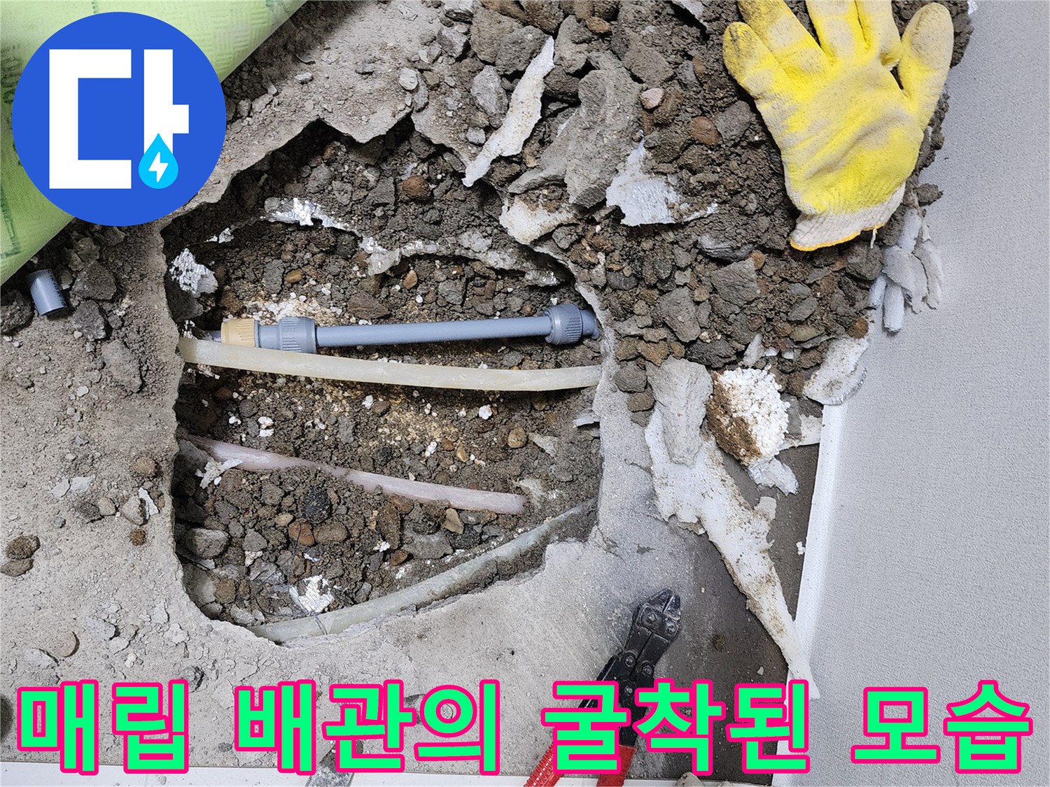 바닥을 파내어 드러난 노출 배관과 작업 도구들