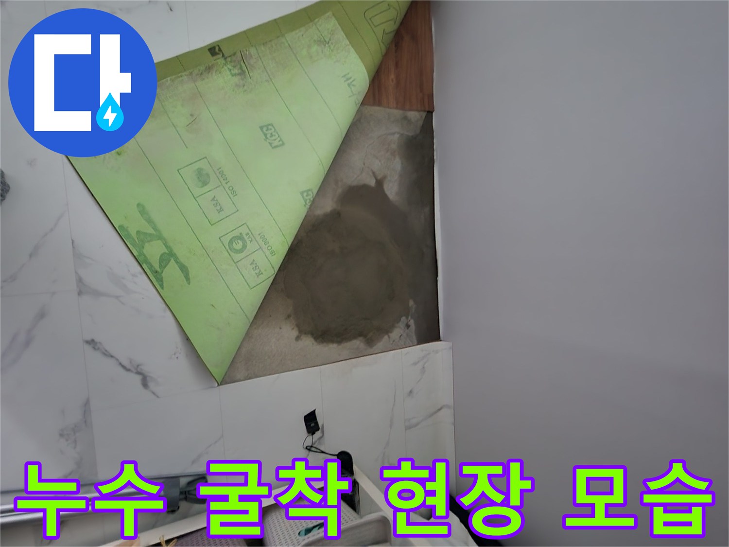 싱크대 앞 바닥 타일을 제거하고 드러난 젖은 바닥면의 모습