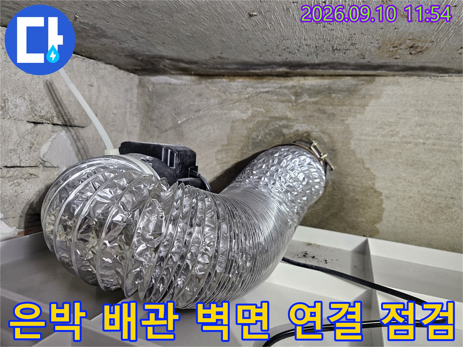 천장 내부에 설치된 은박 소재의 유연한 배관과 벽체 구멍