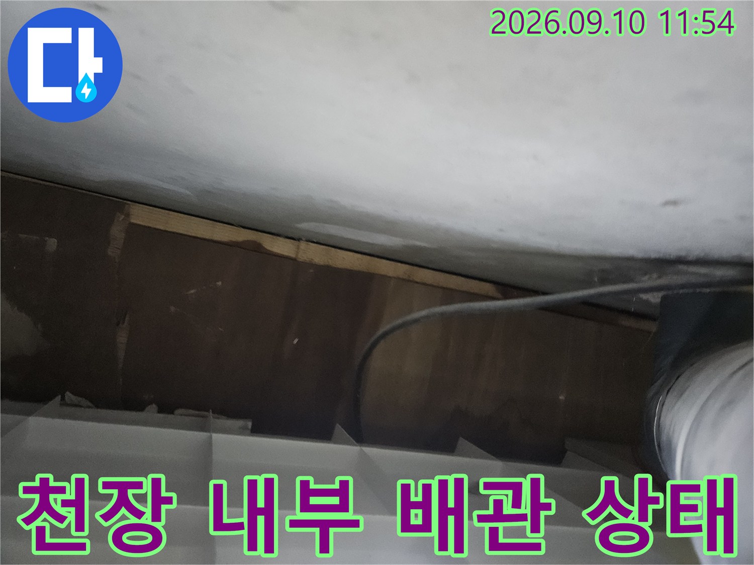 천장 안쪽의 배관과 주변 구조물을 촬영한 사진입니다