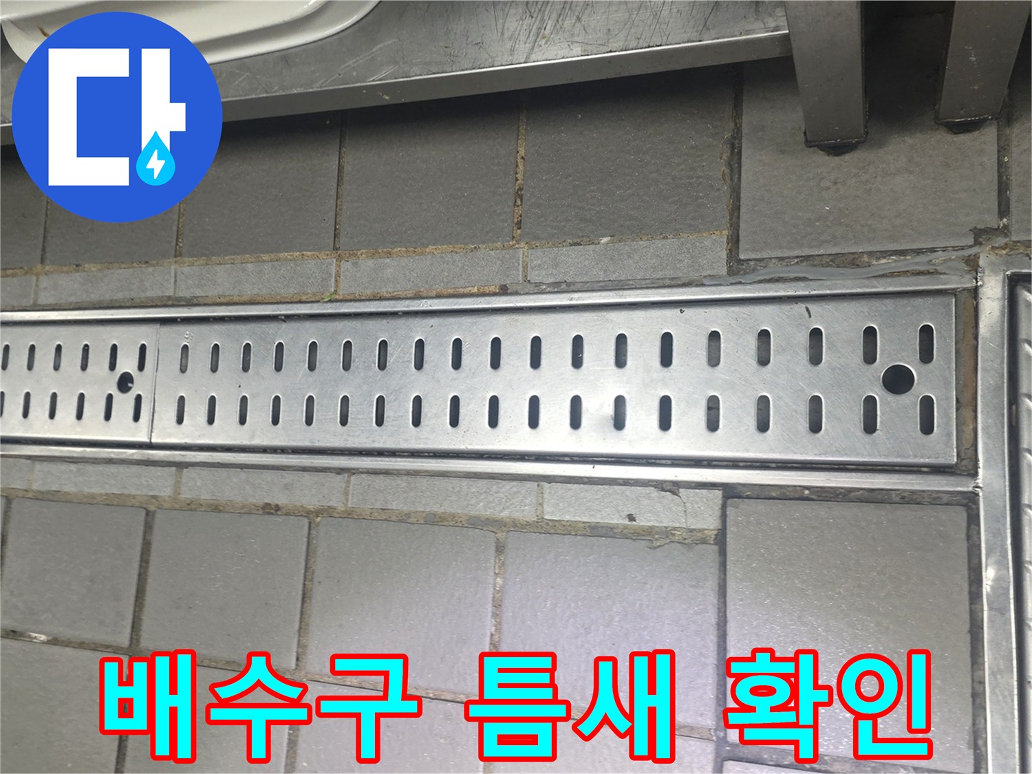 식당 바닥 배수 트렌치와 스테인리스 판넬 연결 부위 근접 촬영