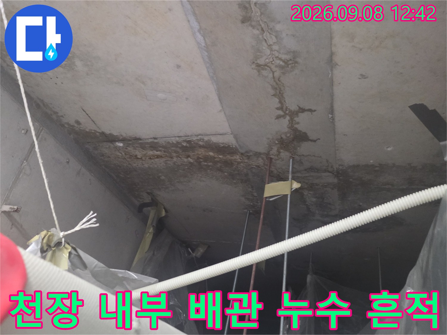 천장 배관 주변에 발생한 어두운 색의 누수 오염 부위