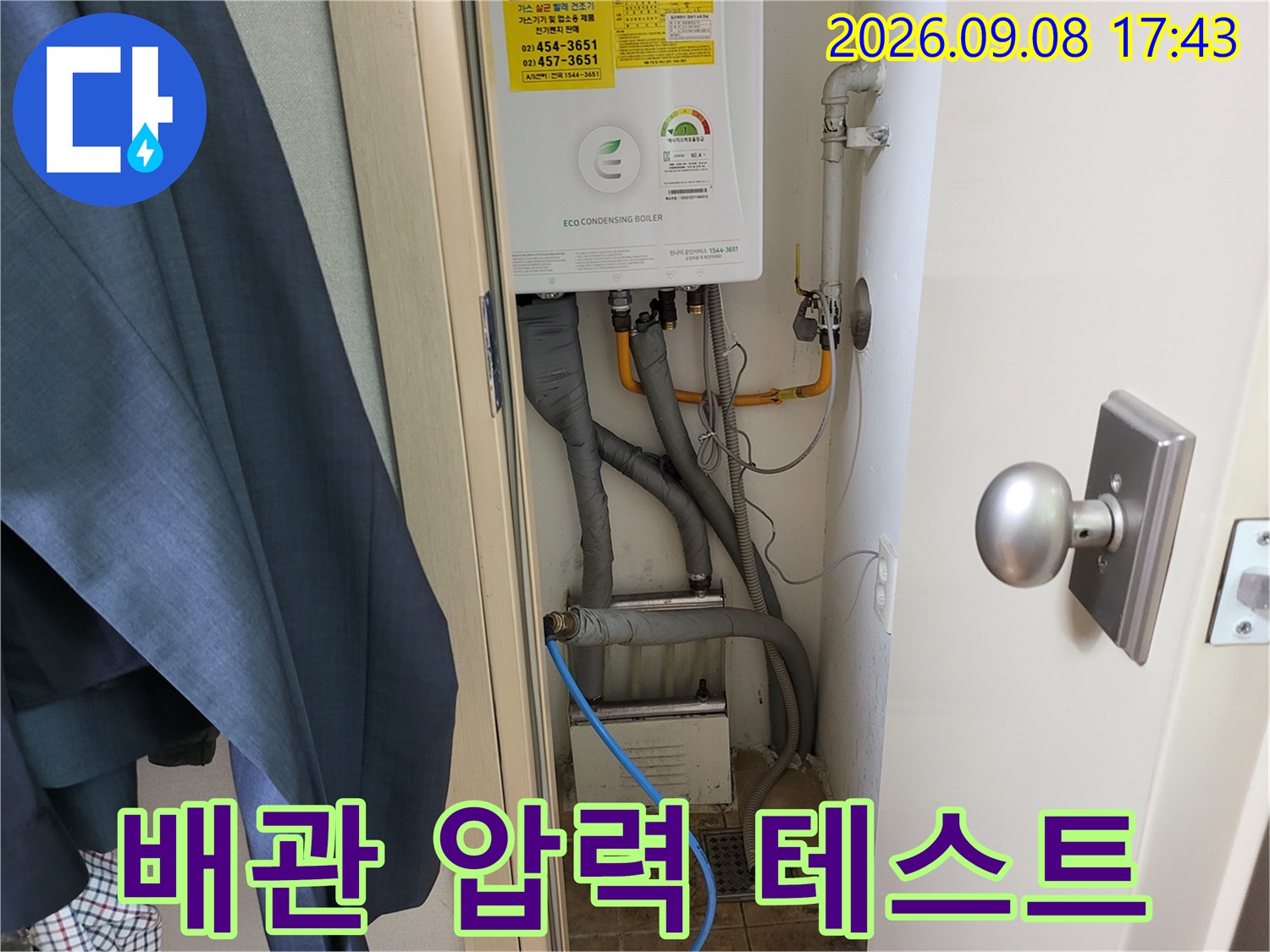 보일러 하단 배관의 연결 부위와 압력계를 활용한 점검 모습