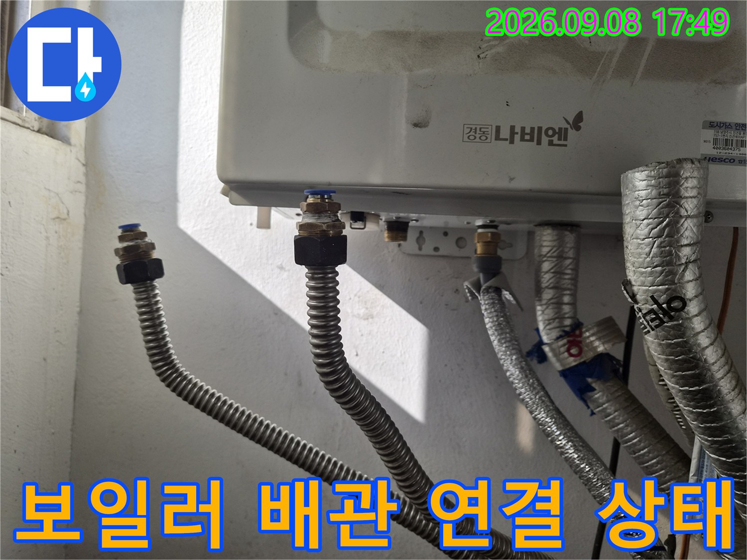 보일러 하단-금속 어댑터와 은색 주름관의 상세 연결 부위