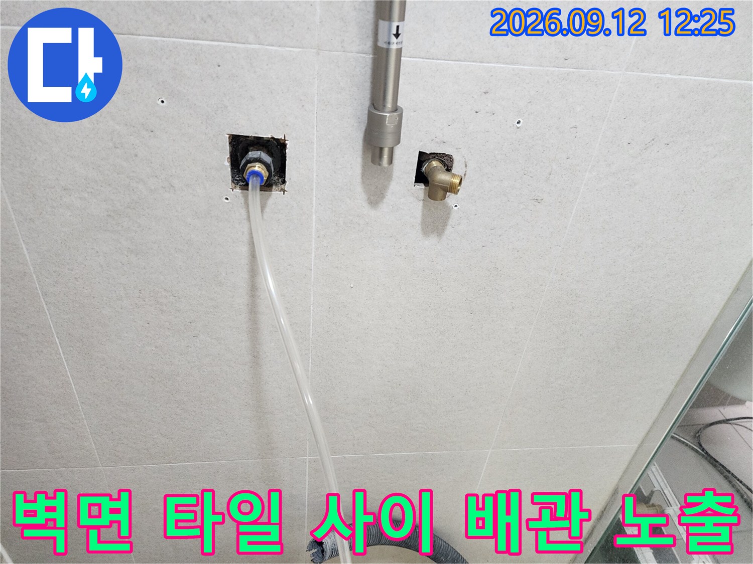 욕실 벽면 타일 사이에 드러난 수전용 매립 배관과 호스 연결부