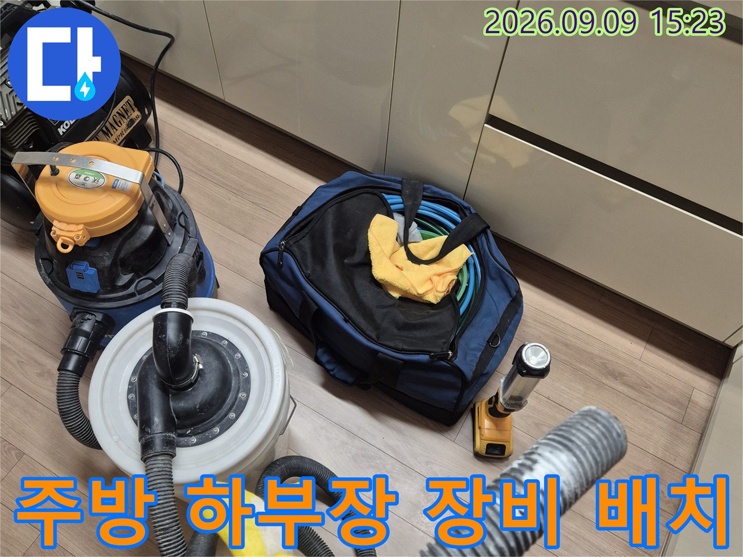싱크대 하단 공간에-설치된 배관 점검용 집진기와 각종 작업 도구들