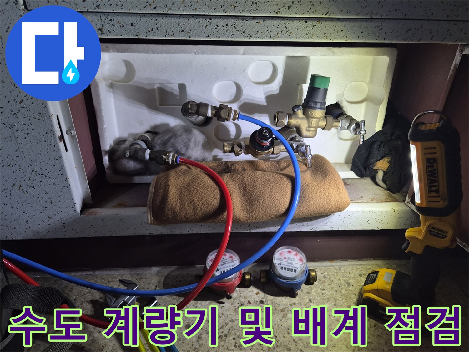 배관 설비와 수도 계량기가 모여 있는 현장 사진입니다.