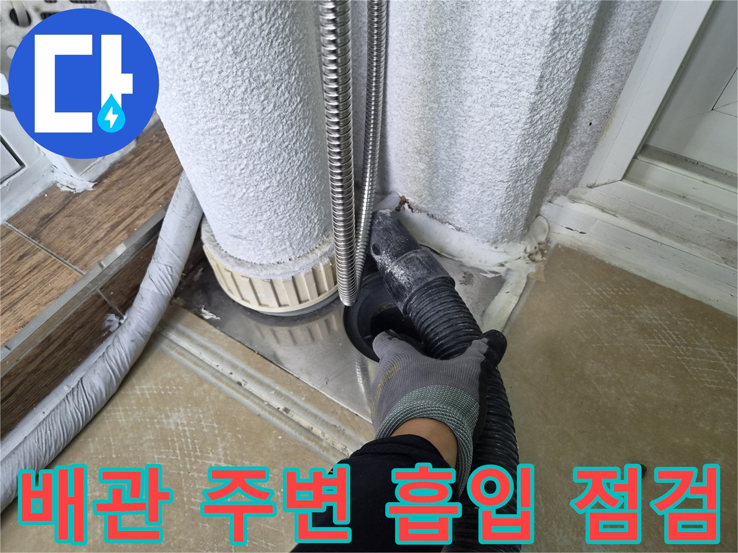 배관 주변의 이물질을 제거하기 위해 흡입 장비를 사용하는 모습