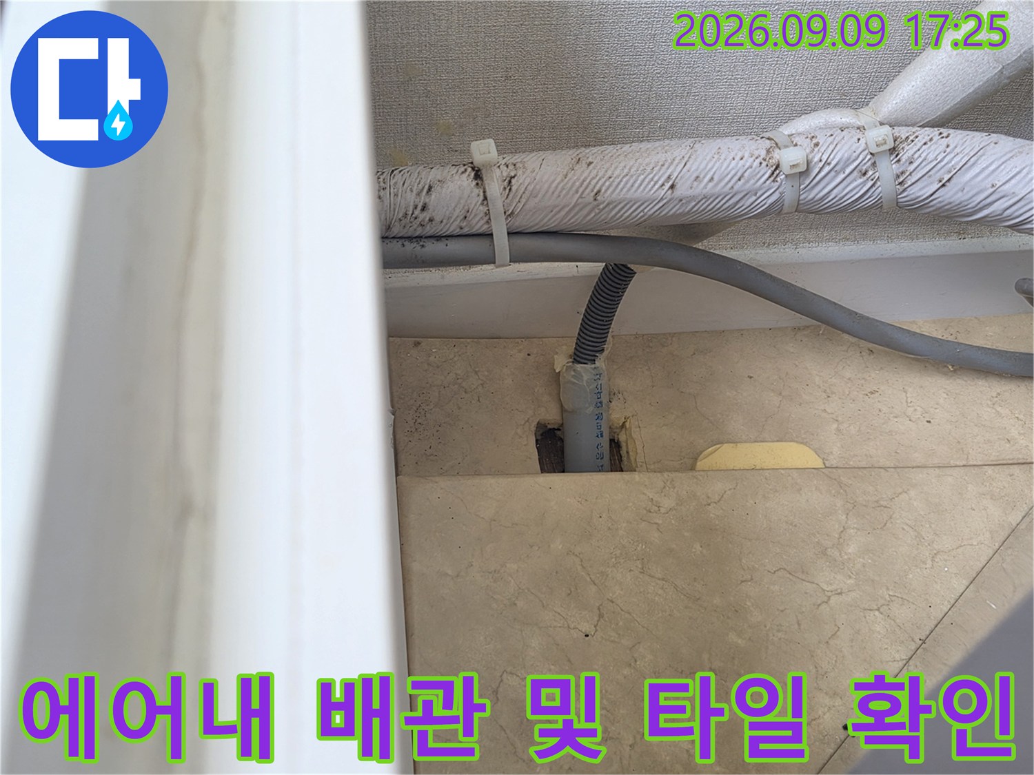 화성시 병점동 현장의 에어컨 드레인 호스와 벽면 마감재 상태를 촬영한 사진입니다.
