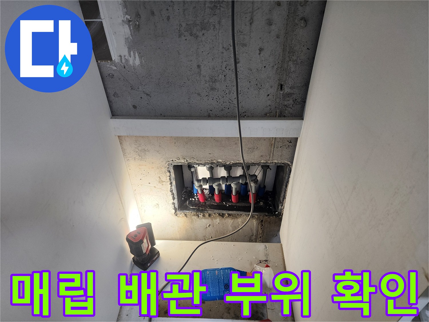 벽면 틈새로 보이는 수도 배관 연결 부위와 작업 장비
